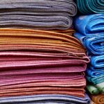 Vibrant and neatly stacked fabrics showcasing an array of colors and patterns, ideal for fashion and textile design.